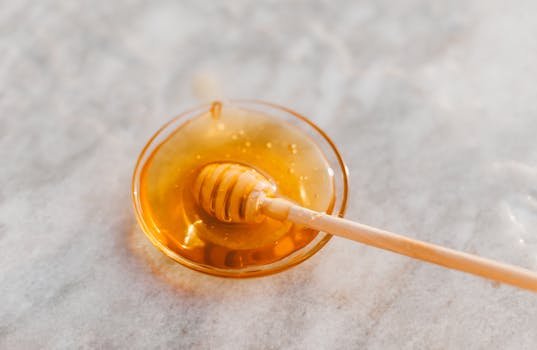pexels-photo-6422029-6422029 A close-up shot of a honey dripper resting in a glass bowl filled with golden honey.